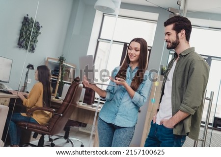 Photo of successful businesspeople working on new project girl showing her trainee his duties in netbook in modern office
