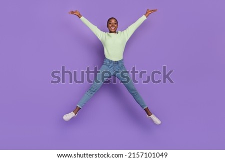 Full length photo of overjoyed cheerful expression lady jumping up have fun isolated on violet color background