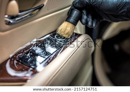 Specialist cleaning car parts with a brush and foam. Professional car detailing Royalty-Free Stock Photo #2157124751
