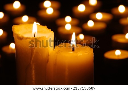 Two burning candles in the dark against the background of blurry lights Royalty-Free Stock Photo #2157138689