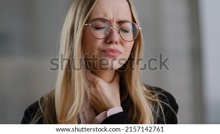 Caucasian business woman girl in glasses worker manager holding throat indoors feels discomfort sore throat respiratory disease covid symptom panic attack suffocation lack of air suffering from asthma Royalty-Free Stock Photo #2157142761