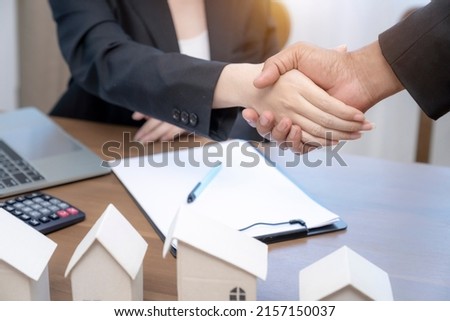 Real estate broker shaking hand with customer