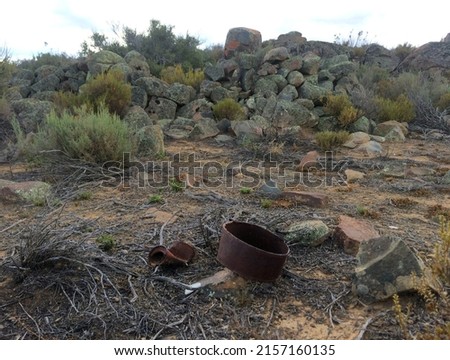 Rusty metal artefacts lying near an Anglo Boer War archaeological site - South Africa. Royalty-Free Stock Photo #2157160135