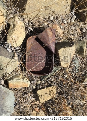 Rusty pilchard tin - artefact lying near an Anglo Boer War archaeological site - South Africa. Royalty-Free Stock Photo #2157162315