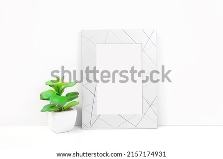 Silvery frame with a flower on a white background. Frame mockup for your design.