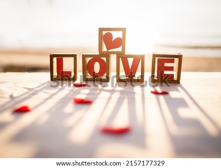 Silhouette shot of love message written in wooden blocks with sunset.Romantic concept.