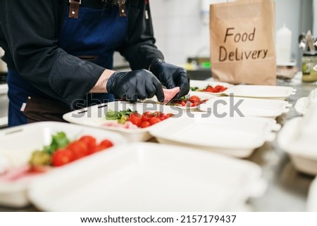 Food in disposable dishes ready for delivery. The chef prepares food in the restaurant and packs it in disposable lunch boxes. Royalty-Free Stock Photo #2157179437