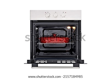 Black oven with silver control panel, three round control knobs. Open door, with a red baking dish, inside lights on. Front view. Isolate on white