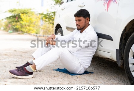 Sad thoughtful cab driver sitting by leanings to car on road - concept of business loss, bankrupt and family problems Royalty-Free Stock Photo #2157186577