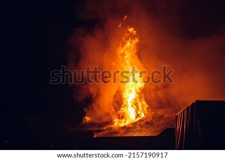 House on fire at night. Topics of arson and fires, disasters and extreme events. Royalty-Free Stock Photo #2157190917