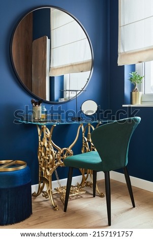 Stylish composition of woman corner in modern glamour interior design with vanity table, big rounded mirror and beautiful personsl accessories. Template.