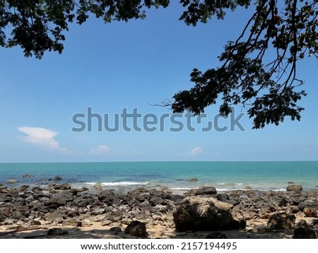 A picture of the southern coast of Thailand with rocks during the day time.