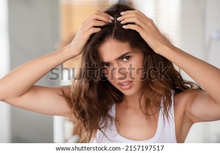Discontented Woman Suffering From Dandruff Problem Looking At Hair Flakes Standing In Modern Bathroom Indoor. Head Skin Health And Haircare Treatment Concept