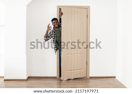 Cheerful African American Guy Gesturing Okay Standing In Opened Door Smiling To Camera Approving His New Apartment Posing At Home. Everything Is OK. Great Real Estate Offer Concept