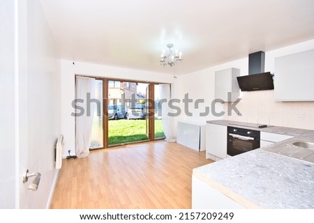 Contemporary Kitchen with large bifolding doors with green viewing in a modern apartment in London UK Royalty-Free Stock Photo #2157209249