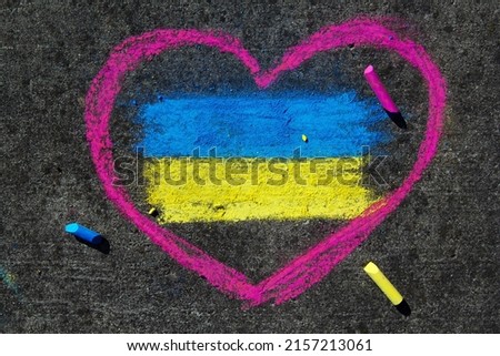 Flag of Ukraine and pink heart. Chalk drawing on sidewalk. Support for Ukraine. 