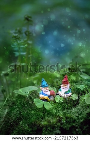 little toy gnomes in mystery fairytale forest, abstract blurred dark green background. magic friends dwarfs, fantasy nature image. harmony beautiful spring summer season.