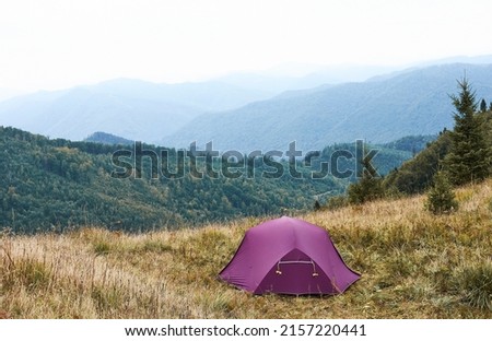 Purple tent in the mountains. Mountain landscape. Can be used as a background.