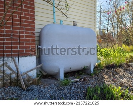 A closeup shot of an oil tank against a house. Royalty-Free Stock Photo #2157221025