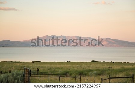 Honey Lake near Susanville California. Gorgeous evening sky with meadow and cattle grazing near ranch with mountains in the background. Royalty-Free Stock Photo #2157224957