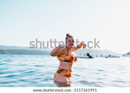 A fat woman enjoys the sea at sunset. Selective focus. High quality photo