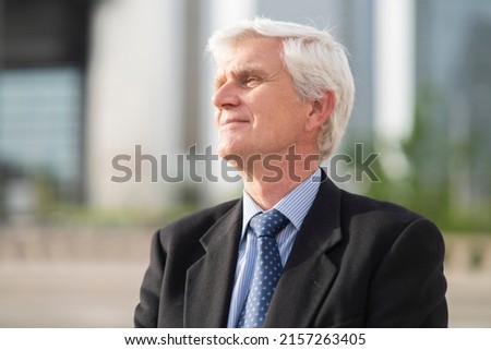portrait of businessman with gray hair in the city -relaxed man waiting for retirement-