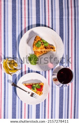 Traditional Spanish snack tortilla patatas served with red piquillo pepper and a glass of wine.