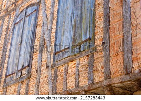Protruding facade of an old traditional European house; protected by a metal mesh.