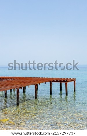 Metal pier and sea view. Rusty skeleton of an old pier and turquoise sea. Unfinished berth in clear water. Sea transport concept Royalty-Free Stock Photo #2157297737