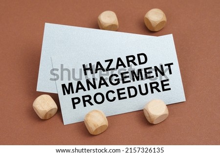 The concept of industrial safety. On a brown surface, wooden cubes and a business card with the inscription - Hazard Management Procedure
