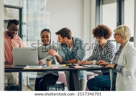 Multiracial young creative people in a modern office while using a laptop. Group of diverse business people working together in the creative co-working space. Royalty-Free Stock Photo #2157346701