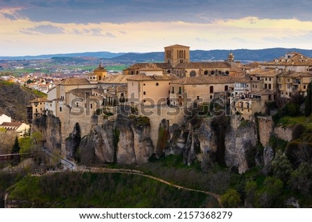 Picturesque view of historic district of Cuenca city on steep spur above deep gorge of Huecar river overlooking Gothic cathedral on sunny spring day, Spain..