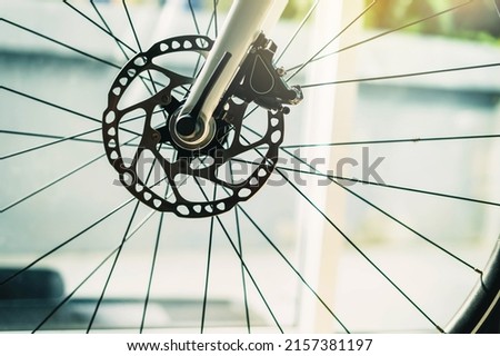 Part of road Bike brake disc in close up. Bicycle shop maintenance technical expertise. details bike front wheel axle disc brake damper. Closeup part of brake disc front wheel mountain bike. Royalty-Free Stock Photo #2157381197