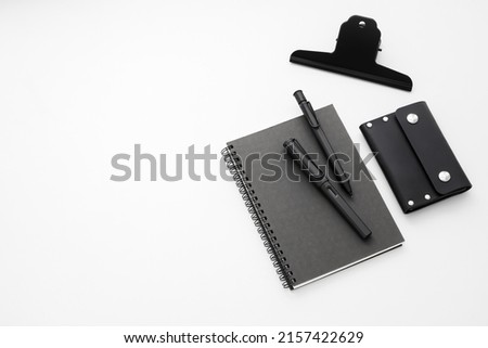 Stationery isolated on white background. Black colour. Pen, Pencil, Note book, Card holder, Black metal paper clip. Minimalist style. Men's Lifestyle. Stationery Design. Space for text.