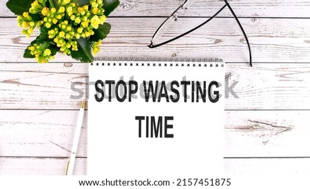 STOP WASTING TIME text concept write on notebook on a wooden background