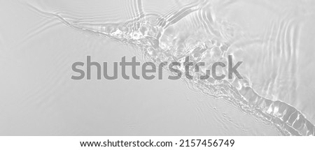 Abstract summer banner background Transparent beige clear water surface texture with ripples and splashes. Water waves in sunlight, copy space, top view. Cosmetics moisturizer micellar toner emulsion