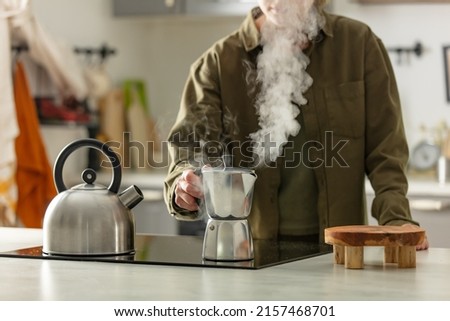 Woman make a coffee in moka pot in kitchen Royalty-Free Stock Photo #2157468701