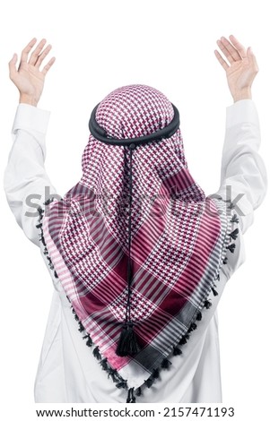 Muslim man with keffiyeh with agal raised hands and praying isolated over white background Royalty-Free Stock Photo #2157471193