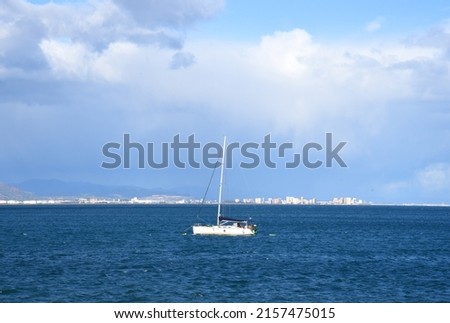 Yacht with a sail. Sailboat at sea on sailing on waves. Yachtsman during training on a sailboat. Skiff and Sailboat in sea near the Spanish coast. Sail sport in Yacht club. Sail boat on waves in sea.  Royalty-Free Stock Photo #2157475015