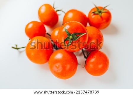 Bunch of ripe tomatoes with one source of natural light. Ripe tomatoes on vine. Ripe red tomatoes in water drops Royalty-Free Stock Photo #2157478739
