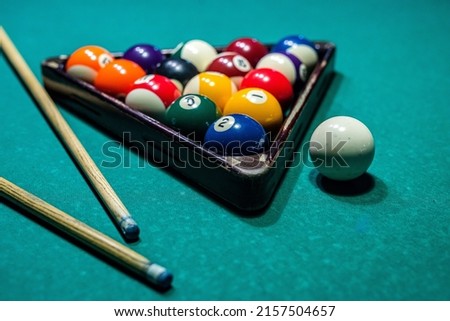 beautiful game of colored layers on a green table with holes and table lamps. Billiard board game concept