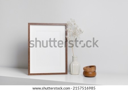 Vertical frame mockup in white minimalistic interior with flowers decorations