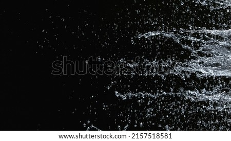 Freeze motion of water splash on black background. Filmed on high speed cinema camera, 1000 fps. Royalty-Free Stock Photo #2157518581