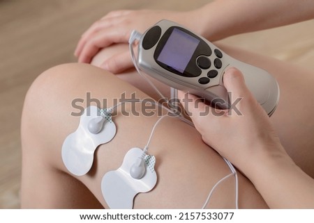 Electrodes of modern acupuncture and anti-cellulite massagers on the legs of a girl in problem areas. Home physiotherapy Royalty-Free Stock Photo #2157533077