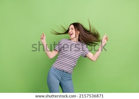 Portrait of attractive dreamy cheerful brown-haired girl dancing moving having fun isolated over bright green color background