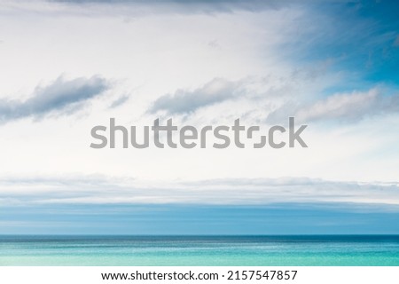 Sky with white and blue clouds over the blue sea. Abstract summer nature background. 