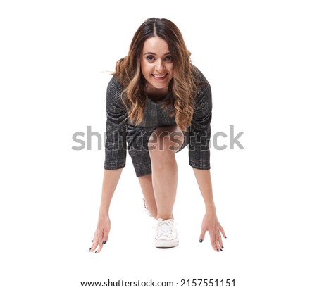 Young competitive businesswoman getting ready for start in a business race, isolated on white background