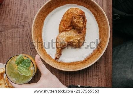 tobacco chicken with cream sauce in a plate on the table