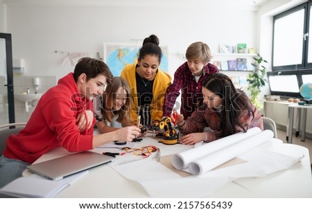 Group of students building and programming electric toys and robots at robotics classroom Royalty-Free Stock Photo #2157565439