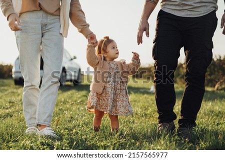 Baby Daughter with Parents Walking Outdoors in Field at Sunset, Little Girl with Mom and Dad Having Family Time Royalty-Free Stock Photo #2157565977